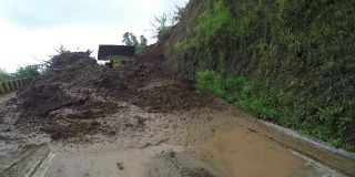 推土机在科迪勒拉悬崖的山路上推着泥石流碎片