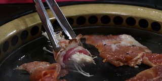 韩国烧烤架。人们在餐馆里用韩式烧烤做菜吃。4 k,特写。
