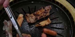 韩国烧烤架。人们在餐馆里用韩式烧烤做菜吃。4 k,特写。