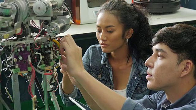 亚洲年轻电子工程师在实验室建造和修理机器人。有技术或创新观念的人。