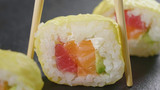 寿司，生鱼片，浦城和夜拍的微距镜头。典型的日本菜，包括米饭、鲑鱼或金枪鱼、虾和浸在酱油中的鱼卵。