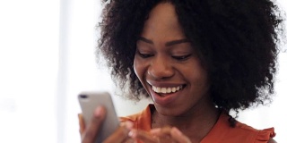 快乐的非裔美国女人拿着智能手机