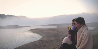 雾蒙蒙的湖面上的神奇早晨!两个朋友早上在湖上喝茶聊天