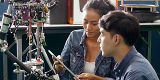 团队工程师在车间协作开发机器人原型项目。有技术或创新观念的人。4 k决议。