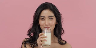 迷人的亚洲女人喝牛奶。