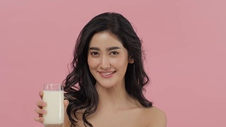 迷人的亚洲女人喝牛奶。视频素材模板下载