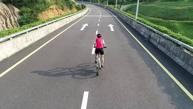 鸟瞰图的女子骑自行车下匝道高速公路