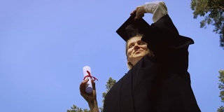 快乐快乐的女毕业生把毕业帽抛向空中