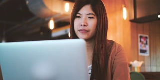 4k视频场景的亚洲女商人在休闲西装工作和咳嗽前笔记本电脑在共同工作空间，商业健康和症状的概念
