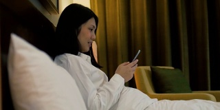 女人在卧室休息时间使用手机