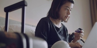 一个年轻女子在酒店房间里用笔记本电脑工作