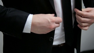 商人在他的黑夹克上扣一颗纽扣视频素材模板下载
