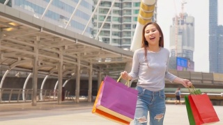 快乐的亚洲女人与购物袋视频素材模板下载