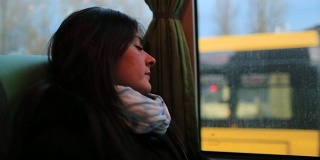一段女乘客在公交车上睡觉的视频。乘客女孩睡在移动的公交车上