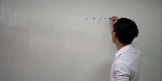年轻英俊的亚洲数学老师正在白板上写数学公式。教育与办学理念