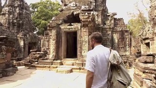 一个热爱旅游的年轻人在亚洲的日落时分探索古庙视频素材模板下载