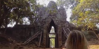 柬埔寨一名年轻女子跑进寺庙大门的慢镜头