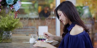 在咖啡馆吃蓝莓奶酪蛋糕的女人