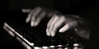 黑客为了保密而在电脑上工作。(镜头包括黑暗，纹理，噪音和光线效果)