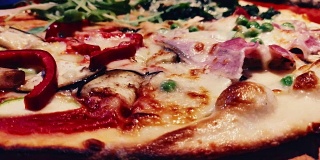 特写的热和新鲜的披萨奶酪，意大利腊肠和芝麻菜