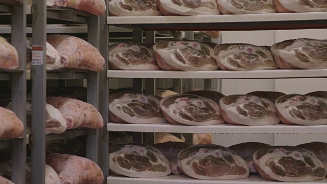 在一个火腿工厂里，根据古老的意大利传统，火腿经过各种各样的工序后被挂起来调味。