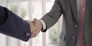 慢动作——在招聘会议后握手以达成协议。两个自信的亚洲商人在办公室开会时握手，成功，交易，问候和合作伙伴的概念。
