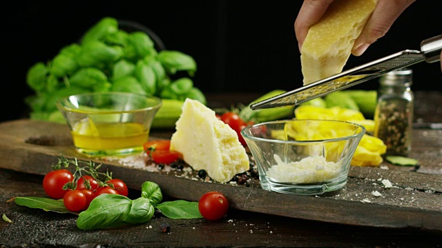 一个厨师磨碎的帕玛森奶酪，典型的意大利奶酪，在盘子里刚刚酿造。