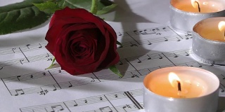 摘要:燃烧的烛光和带音符的玫瑰