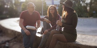 日落时分，一群朋友在城市街道上，喝着瓶装水，吃着薯条。