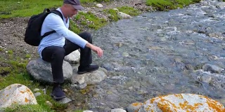 快乐的游客来到小溪边，坐在石头上休息