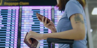 女游客在机场用电话办理登机手续