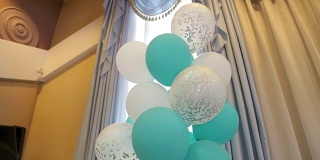 白色和绿色的凝胶球在一个现代酒店的婚礼上飞舞。
