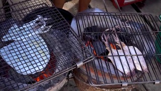 美味的烤鱿鱼和干鱿鱼在泰国的街头小吃摊上，在海边的路上卖视频素材模板下载