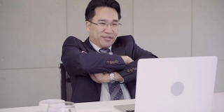 慢动作-成功的亚洲首席执行官，商人穿着西装在办公室的办公桌上用笔记本电脑工作。商人的工作理念。