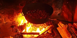 秋天的一天，用平底锅在火上烤栗子