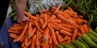 一个男人在农贸市场买胡萝卜