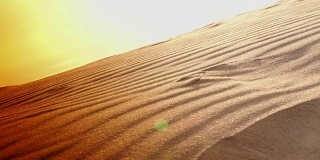 日落和从海上沙丘吹起的沙子