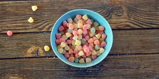 彩色的糖果在慢镜头中落入碗中