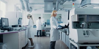 研究团队的科学家在计算机上工作，与医疗设备，分析血液和遗传物质样本的特殊机器在现代实验室。