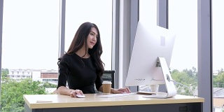 女商人在工作场所使用电脑。年轻的亚洲女商人思考和工作在电脑办公室