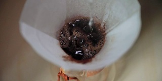 通过滤网滴滤咖啡。用慢动作捕捉。