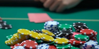 人们在玩扑克，看牌的人在推筹码，全押