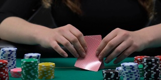 女人看着自己的牌，全力以赴，合理的冒险，扑克赌博
