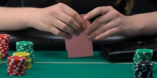女人从钱包里拿出一堆美元，把所有赌注都押在她的牌上