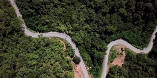 鸟瞰图蜿蜒的道路在森林和汽车驾驶，安全驾驶的概念
