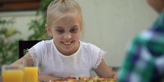 微笑的女孩看着披萨选择最好的切片，家庭传统食物