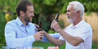 中老年男人敲着啤酒瓶聊天，酿造传统