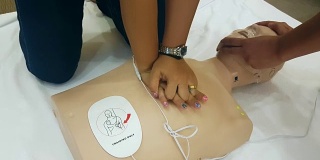 学生在心肺复苏训练班学习如何使用心肺复苏娃娃和AED机抢救紧急情况下的病人