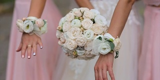 穿着粉色礼服的新娘和伴娘捧着花束。