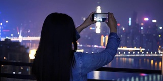 年轻女子正在拍摄城市夜景
